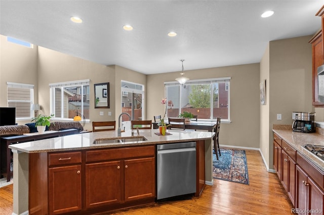 16685 E 101st Ave, Commerce City, CO 80022 - kitchen featuring light stone countertops, a sink, light wood finished floors, dishwasher, and an island with sink