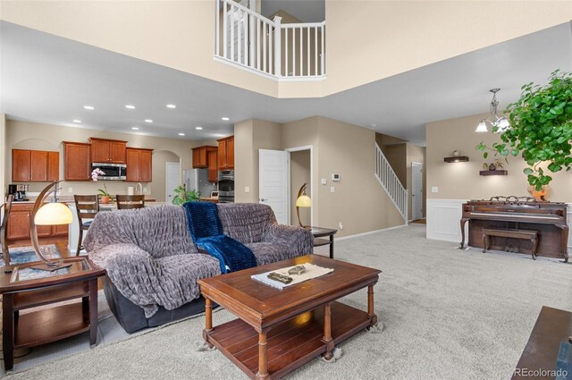 16685 E 101st Ave, Commerce City, CO 80022 - living room featuring light carpet, arched walkways, stairs, recessed lighting, and baseboards