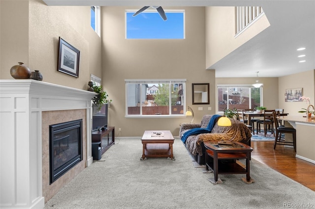 16685 E 101st Ave, Commerce City, CO 80022 - living room featuring baseboards, wood finished floors, a high ceiling, and a fireplace