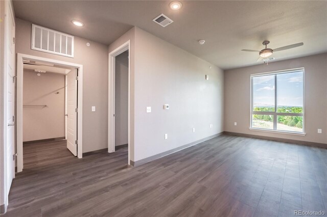 empty room with ceiling fan and dark hardwood / wood-style floors