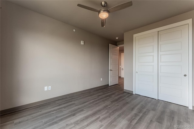 unfurnished bedroom featuring hardwood / wood-style floors, ceiling fan, and a closet