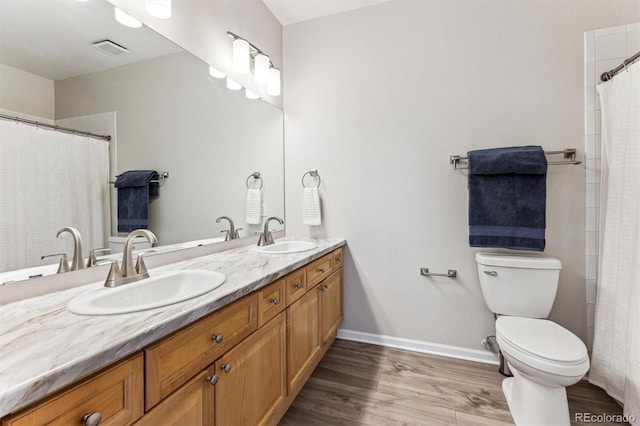 bathroom with toilet, hardwood / wood-style flooring, and vanity