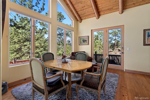 2611 Fox Acres Dr E, Red Feather Lakes, CO 80545 - dining space with wood ceiling with exposed beams, baseboards, light wood finished floors, and high vaulted ceiling