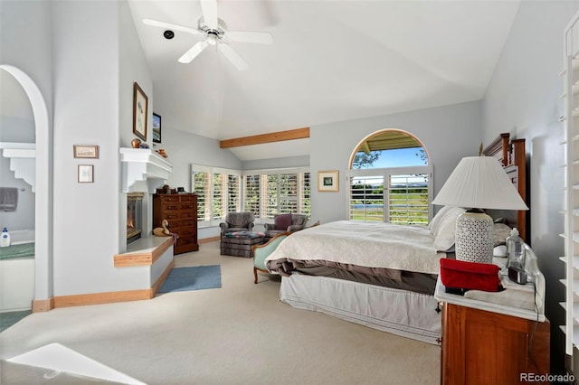 2611 Fox Acres Dr E, Red Feather Lakes, CO 80545 - carpeted bedroom featuring lofted ceiling, a glass covered fireplace, ceiling fan, and arched walkways