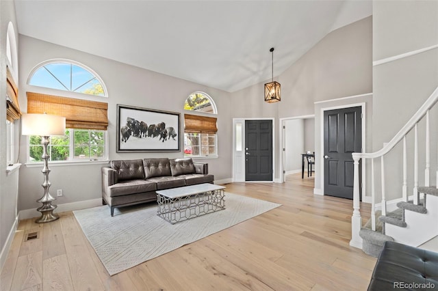 9432 La Quinta Way, Lone Tree, CO 80124 - living area featuring stairway, light wood finished floors, high vaulted ceiling, and baseboards
