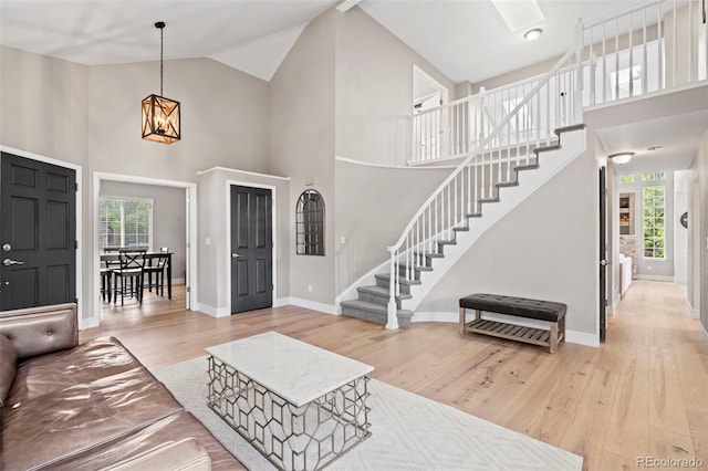 9432 La Quinta Way, Lone Tree, CO 80124 - living area featuring high vaulted ceiling, stairs, wood finished floors, and baseboards