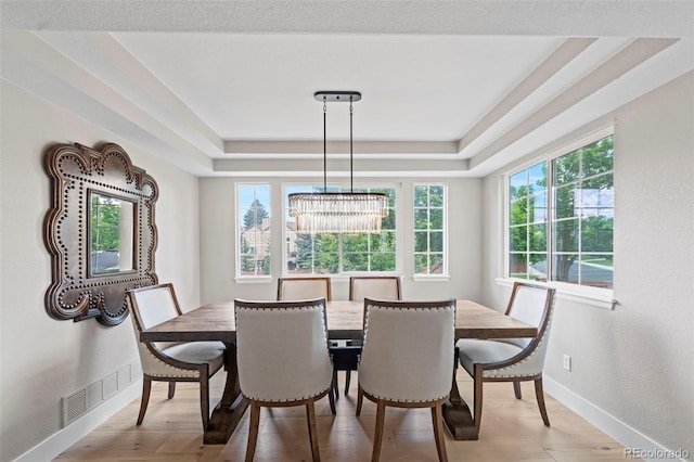 9432 La Quinta Way, Lone Tree, CO 80124 - dining area featuring baseboards, a tray ceiling, a chandelier, and wood finished floors