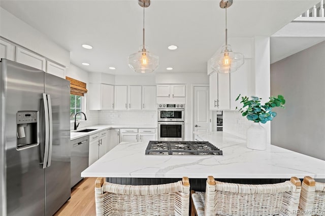 9432 La Quinta Way, Lone Tree, CO 80124 - kitchen with stainless steel appliances, a breakfast bar, white cabinets, light stone counters, and tasteful backsplash