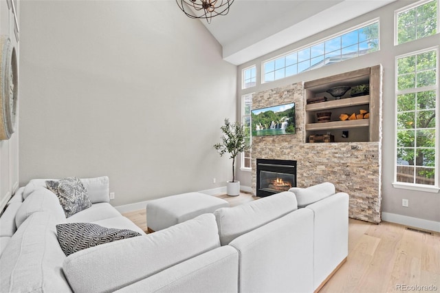 9432 La Quinta Way, Lone Tree, CO 80124 - living room featuring light wood-style flooring, a glass covered fireplace, and high vaulted ceiling