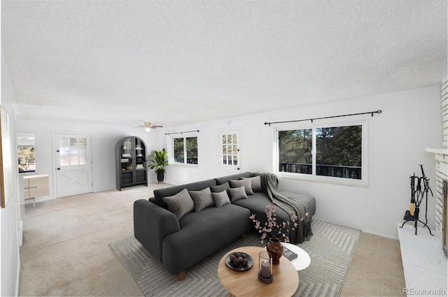 living room with light carpet, ceiling fan, and a healthy amount of sunlight