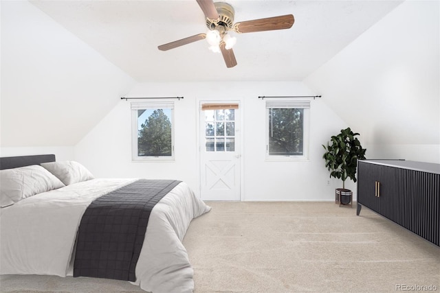 carpeted bedroom with ceiling fan and vaulted ceiling