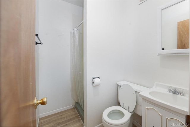 bathroom with curtained shower, vanity, wood-type flooring, and toilet