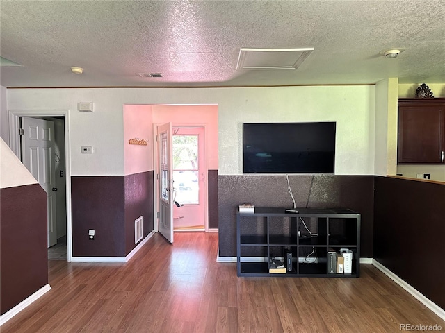 unfurnished living room with a textured ceiling and hardwood / wood-style floors