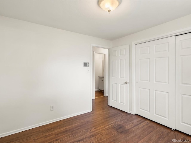 945 Emerald St, Broomfield, CO 80020 - unfurnished bedroom featuring baseboards, dark wood finished floors, and a closet