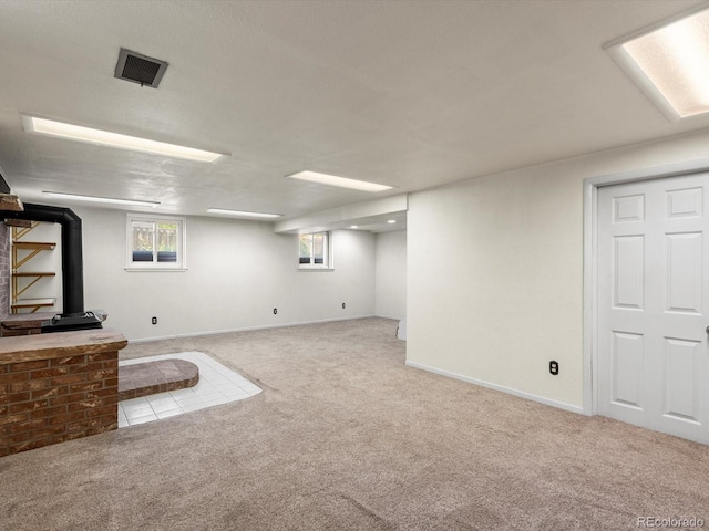 945 Emerald St, Broomfield, CO 80020 - basement with a wood stove, carpet flooring, and baseboards