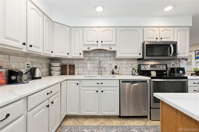 kitchen with light tile patterned floors, white cabinetry, sink, and appliances with stainless steel finishes