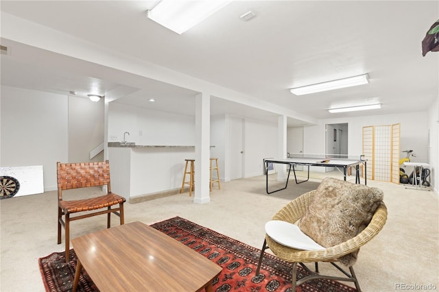 recreation room with indoor bar and light colored carpet