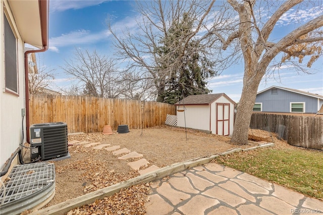 view of yard with central AC and a storage shed