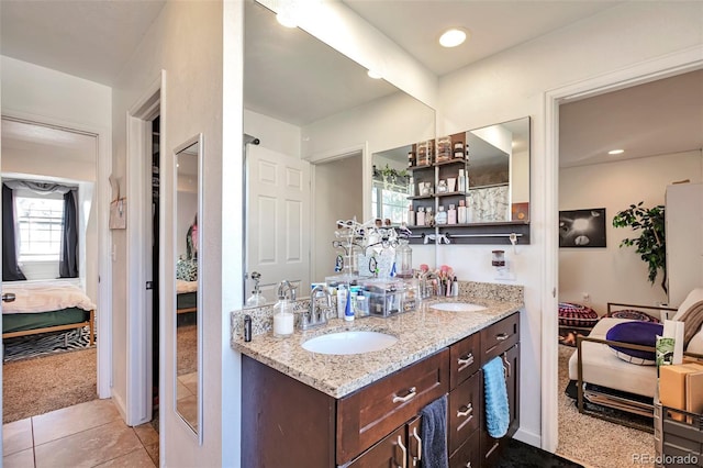 full bath with ensuite bathroom, double vanity, and tile patterned floors
