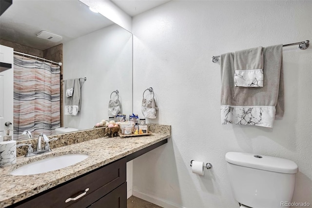 bathroom featuring toilet, vanity, a shower with shower curtain, and baseboards
