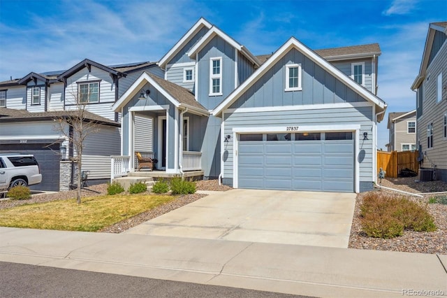 view of front of home with board and batten siding, fence, concrete driveway, and a garage