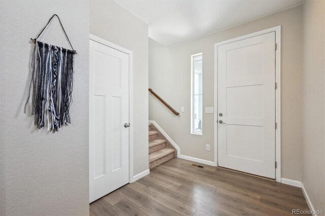 27837 E 8th Ave, Aurora, CO 80018 - entryway featuring baseboards, stairs, wood finished floors, and visible vents