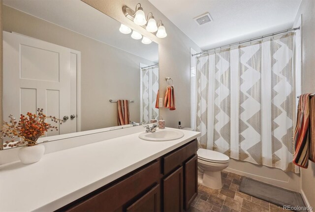 27837 E 8th Ave, Aurora, CO 80018 - bathroom featuring visible vents, vanity, toilet, a shower with shower curtain, and stone finish floor