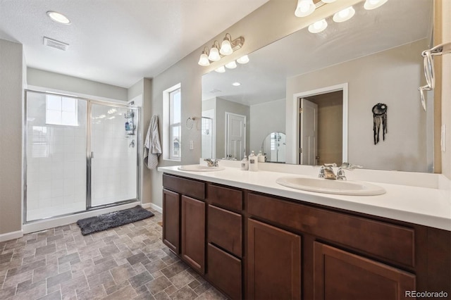 full bathroom with a sink, a healthy amount of sunlight, a stall shower, and visible vents