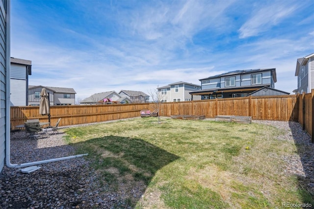 view of yard featuring a fenced backyard and a residential view