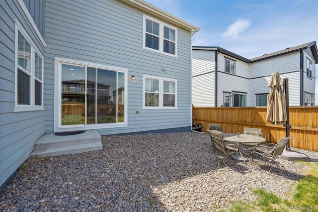 back of property with fence and a patio area