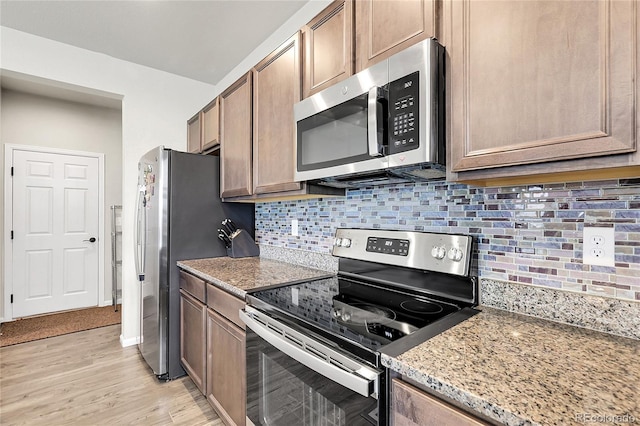 6484 N Ceylon Ct, Denver, CO 80249 - kitchen with stainless steel appliances, light wood finished floors, decorative backsplash, and light stone countertops