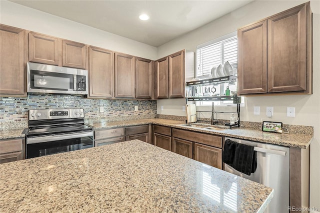 6484 N Ceylon Ct, Denver, CO 80249 - kitchen featuring stainless steel appliances, a sink, decorative backsplash, light stone counters, and recessed lighting
