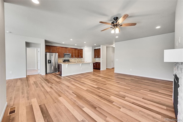 unfurnished living room with ceiling fan and light hardwood / wood-style floors