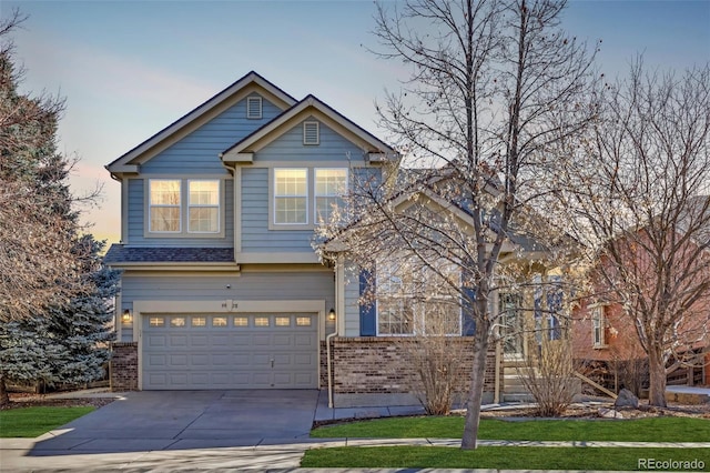 craftsman inspired home featuring a garage, concrete driveway, and brick siding