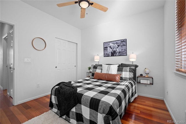 bedroom with dark wood-type flooring, ceiling fan, and a closet