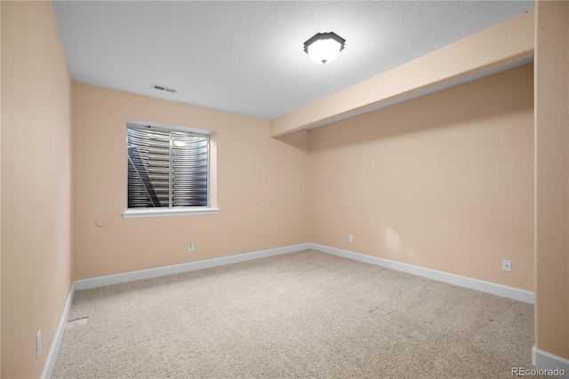 empty room with carpet and a textured ceiling