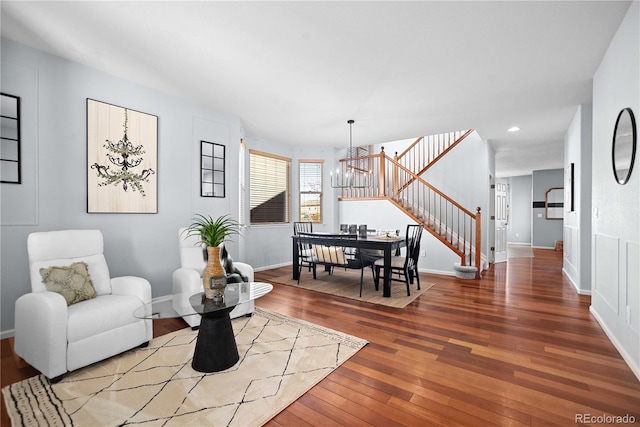 living area with wood-type flooring and a notable chandelier