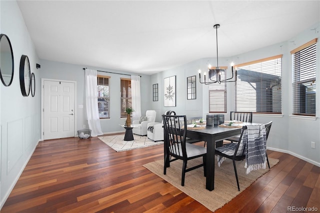 dining space with hardwood / wood-style flooring and an inviting chandelier