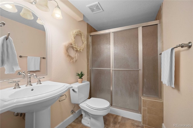 bathroom with tile patterned flooring, sink, toilet, and walk in shower