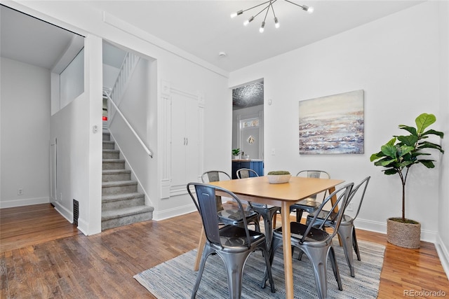 dining space featuring hardwood / wood-style floors and a notable chandelier