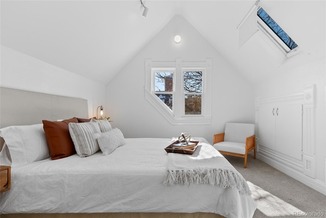 bedroom with carpet floors and vaulted ceiling with skylight