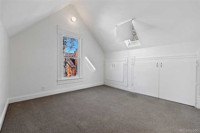 bonus room featuring carpet flooring and vaulted ceiling with skylight