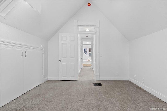 bonus room featuring vaulted ceiling and light carpet