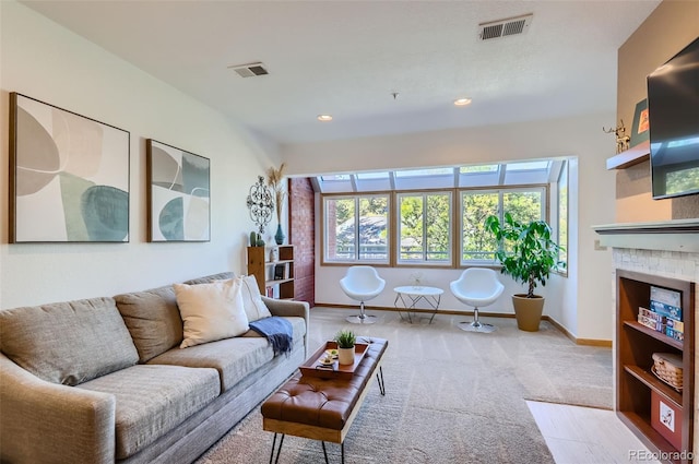 carpeted living room with a tile fireplace