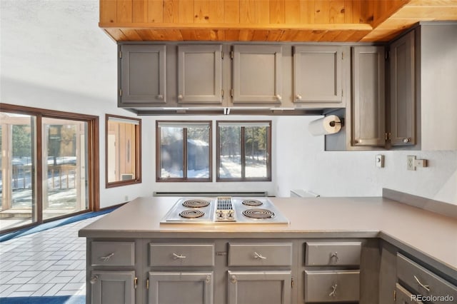 kitchen featuring white electric cooktop, gray cabinets, and wood ceiling