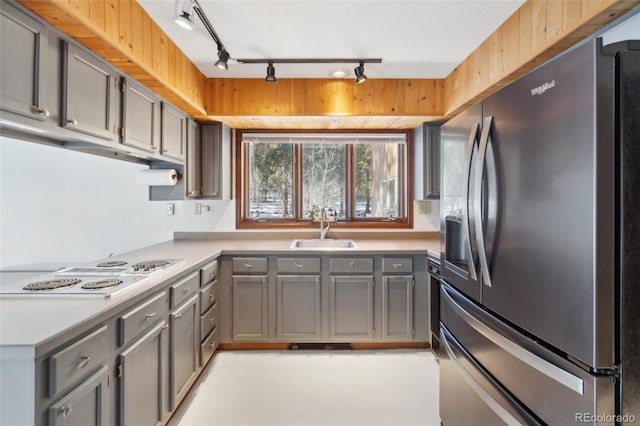 kitchen with white stovetop, rail lighting, sink, gray cabinets, and stainless steel fridge with ice dispenser