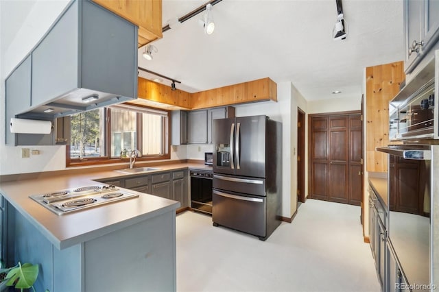 kitchen featuring kitchen peninsula, sink, stainless steel appliances, and track lighting