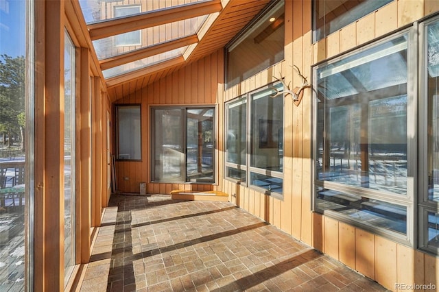 sunroom / solarium featuring vaulted ceiling with skylight