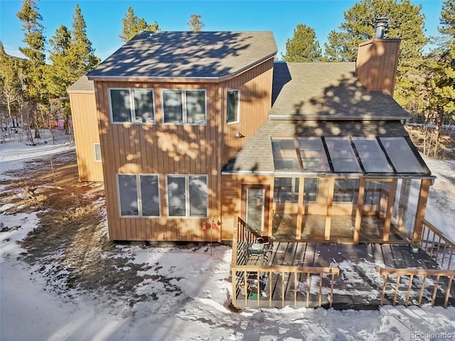 snow covered house with a sunroom