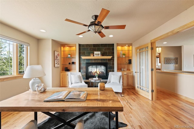 13909 Stone Chimney Ln, Pine, CO 80470 - living area featuring light wood-style floors, recessed lighting, a fireplace, ceiling fan, and built in features